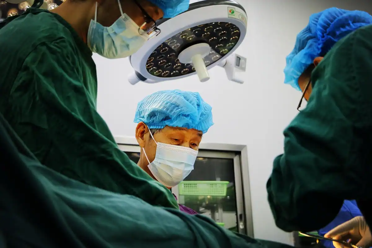 Echipă chirurgicală în sala de operații sub lumina lămpii, într-un spital evaluat pentru acreditare