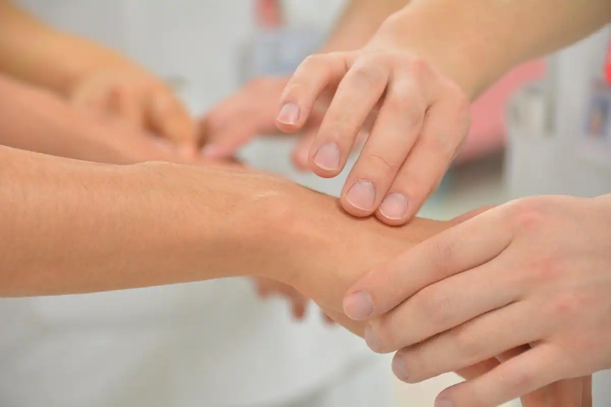 Medicul examinează mâna unui pacient în timpul unui consult de specialitate