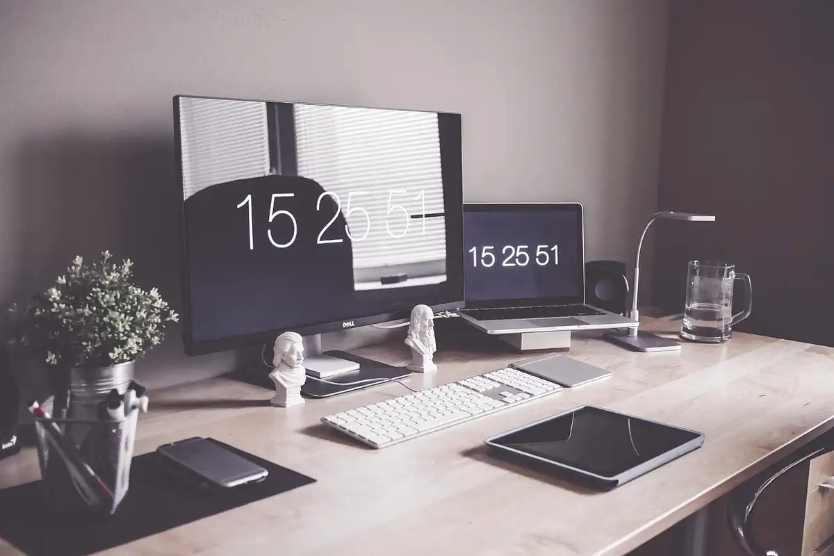 Birou de acasă cu laptop, tabletă și telefon, într-un spațiu de lucru modern și ordonat