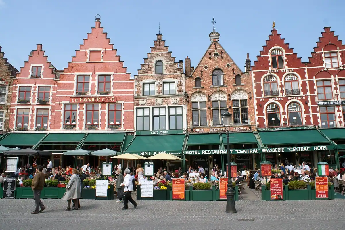 Piața unui oraș european cu case colorate și terase pline de turiști