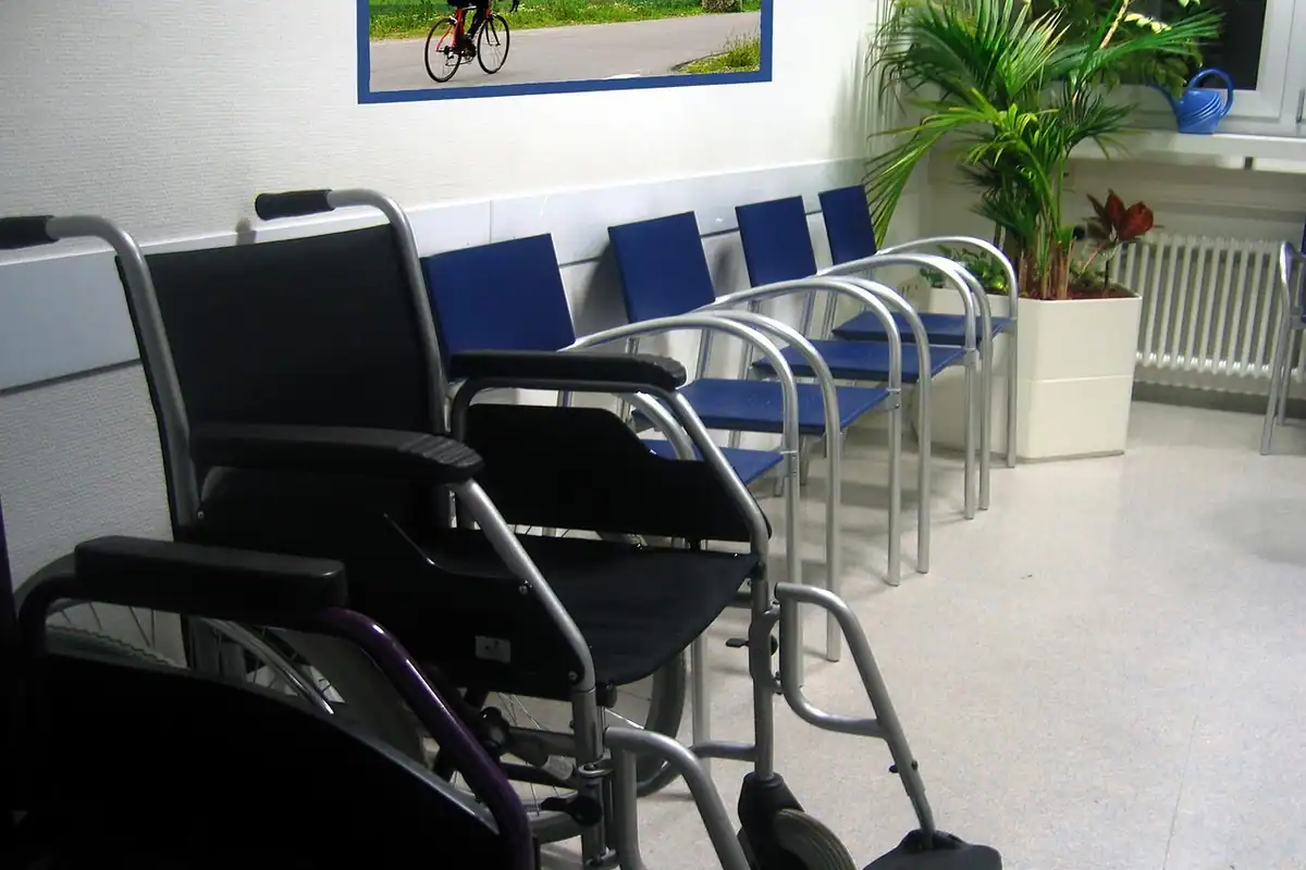 Scaune albastre și un cărucior într-o sală de așteptare din clinică
