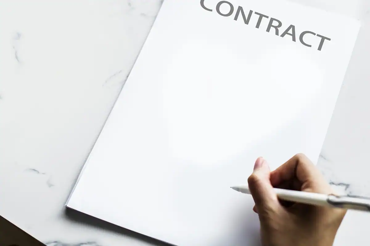 Semnarea unui contract cu un pix cu bilă pe o foaie de hârtie, într-un cadru de afaceri