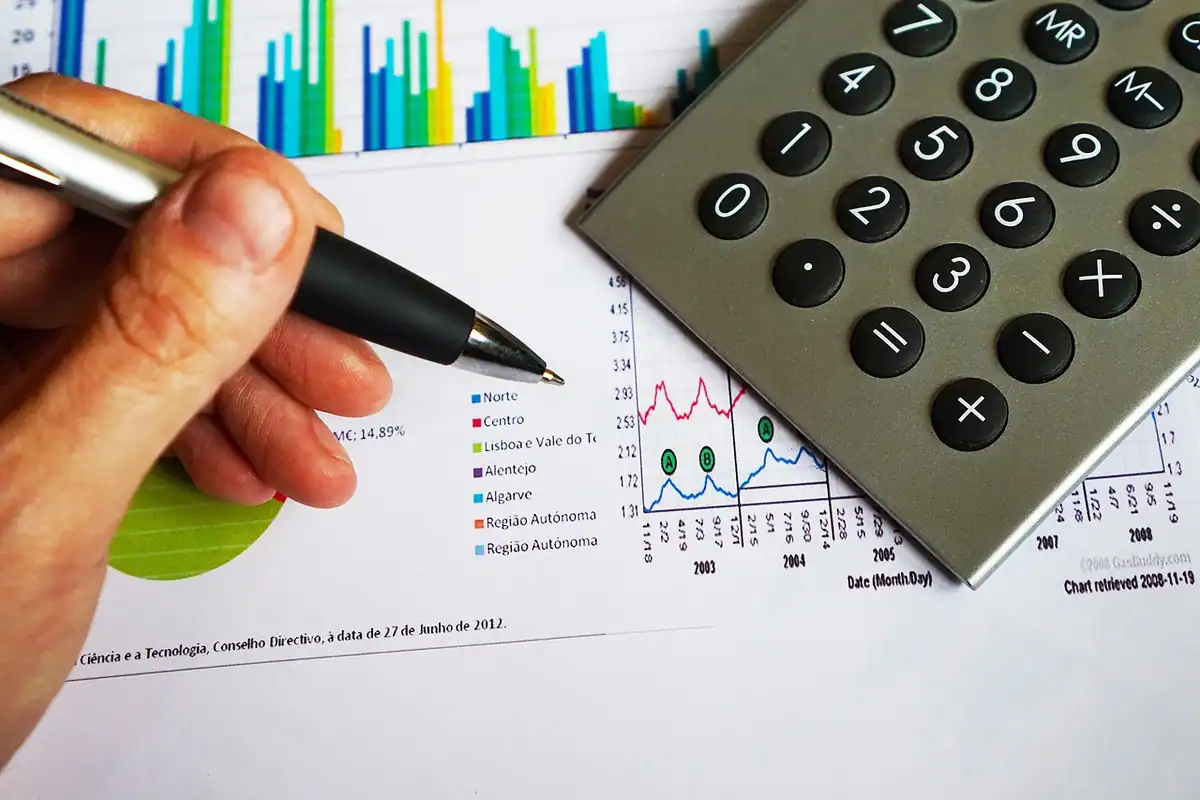 Calculator de birou și pix lângă documente cu grafice și cifre, pentru calcule financiare