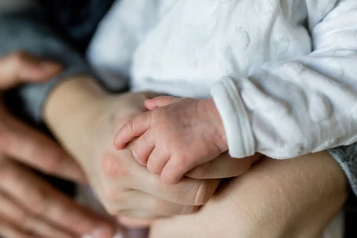 Familie formată din mamă, tată și copil mic, împreună într-un cadru de afecțiune