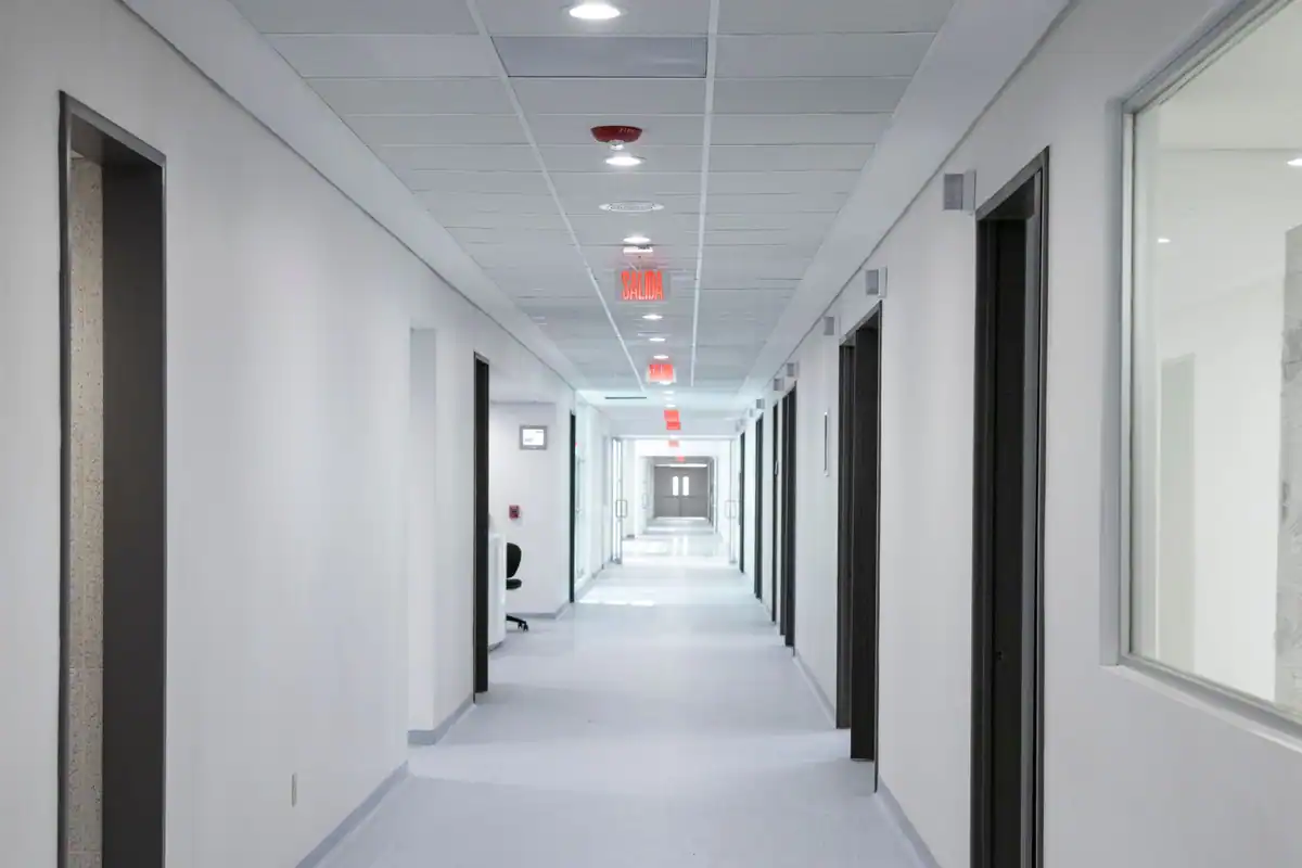 Coridor de spital cu pereți albi, design modern și lumină puternică de sus
