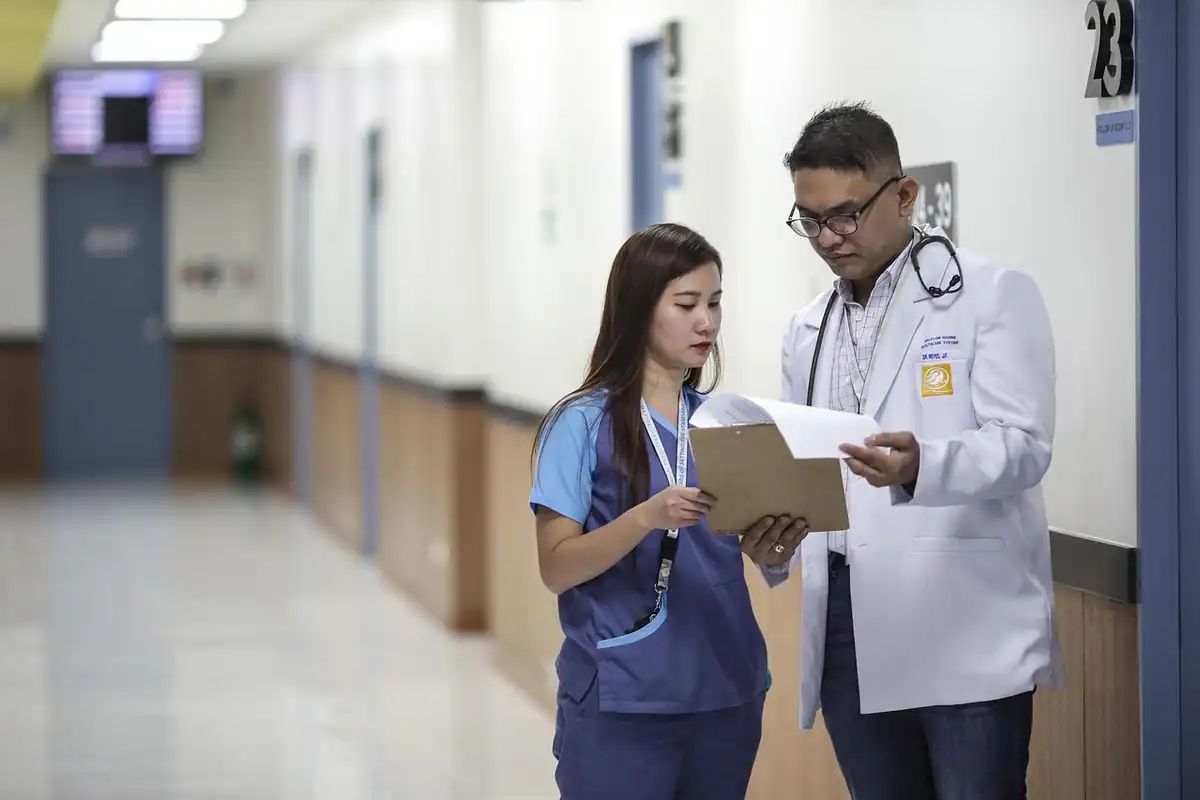 Asistent al unui medic, lucrând într-un birou, într-un cadru profesional