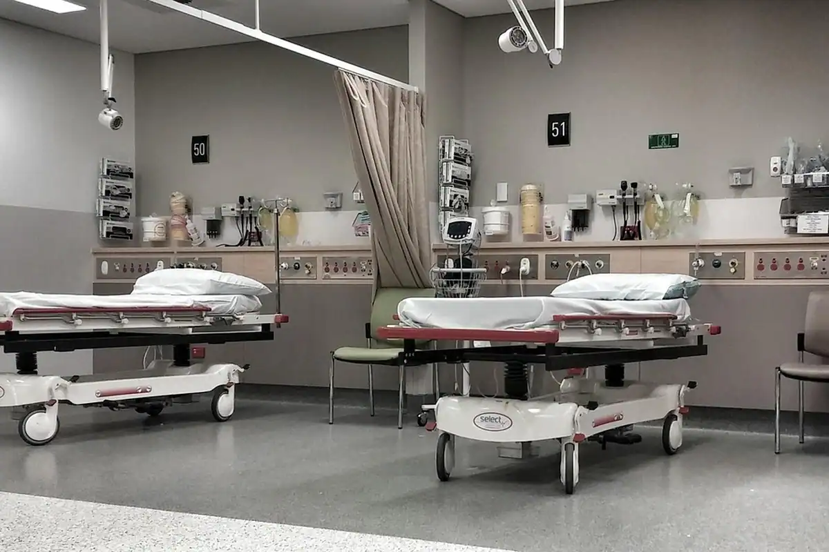 Paturi de spital cu perdele într-o încăpere de primiri urgențe