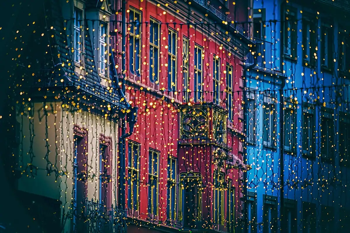 Luminițe de Crăciun aprinse pe o stradă dintr-un oraș, seara, într-o atmosferă festivă