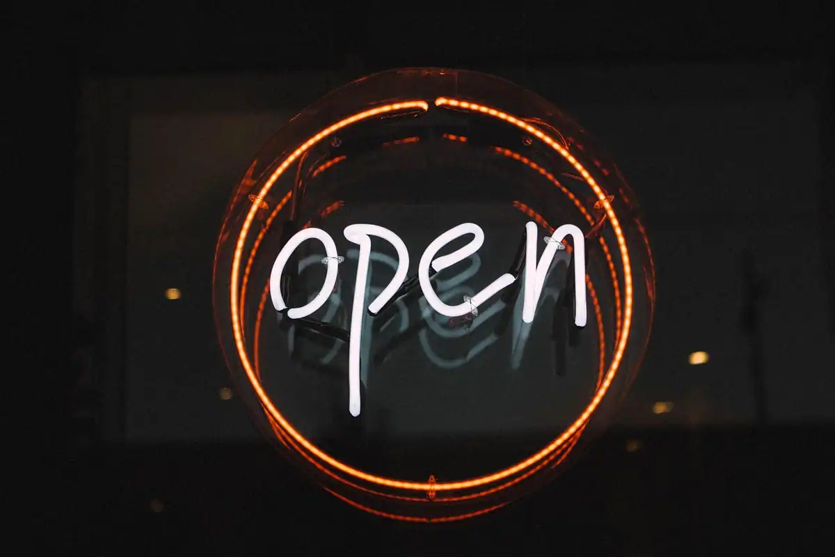 Firmă luminoasă cu neon aprinsă, care indică faptul că locul este deschis