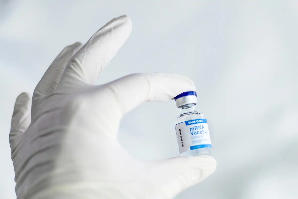 Flacon cu vaccin ținut în mână, într-un cadru legat de vaccinare și sănătate
