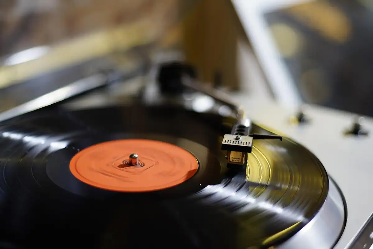 Pick-up de vinil cu disc negru și detalii portocalii, într-un stil retro